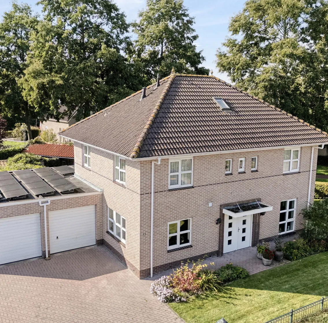 Luchtfoto van de woning met zonnepanelen op de garage