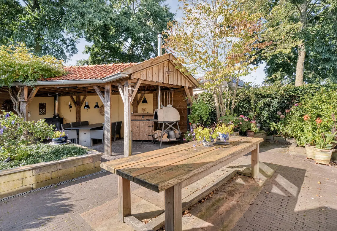 Achtertuin met overkapping en tuintafel